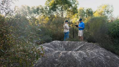 Two Bush Heritage staff inspect a large Malleefowl mound.